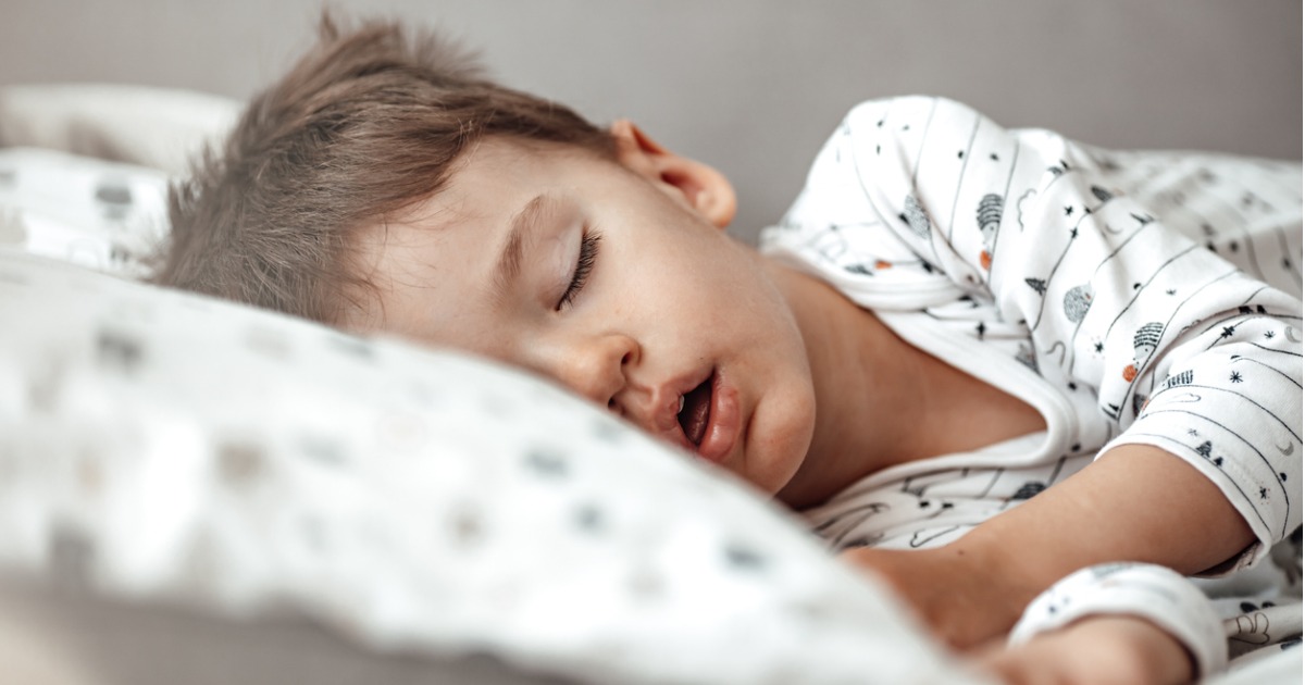 Young boy sleeping in bed