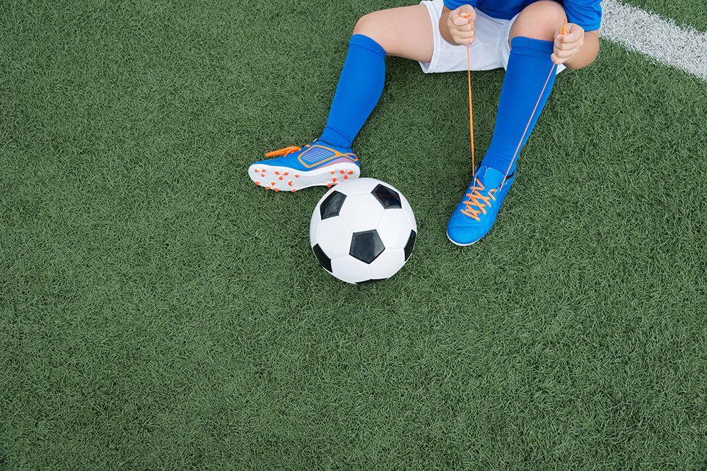 Young kid laces up their cleats