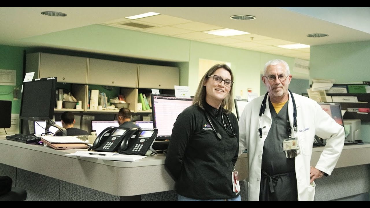 Basia Adams and Garry Lapidus, Co-Directors of the Office of Advanced Practice Providers, stand at front desk on inpatient floor