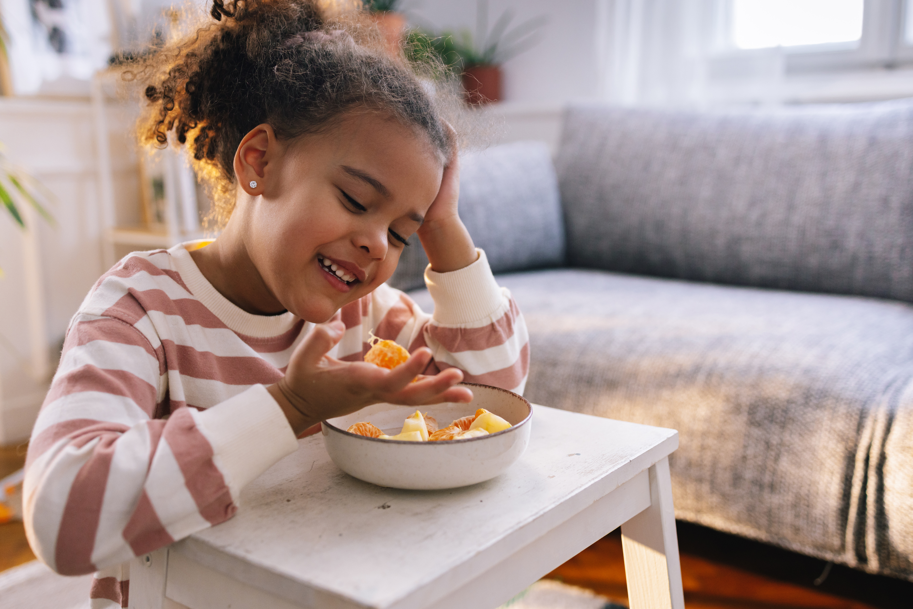 School age child eating a bowl of fruit