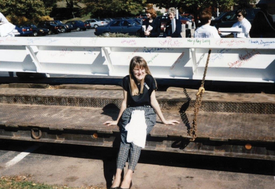 Woman sitting on concrete in front of steel beam for Newington Children's Hospital, circa 1996