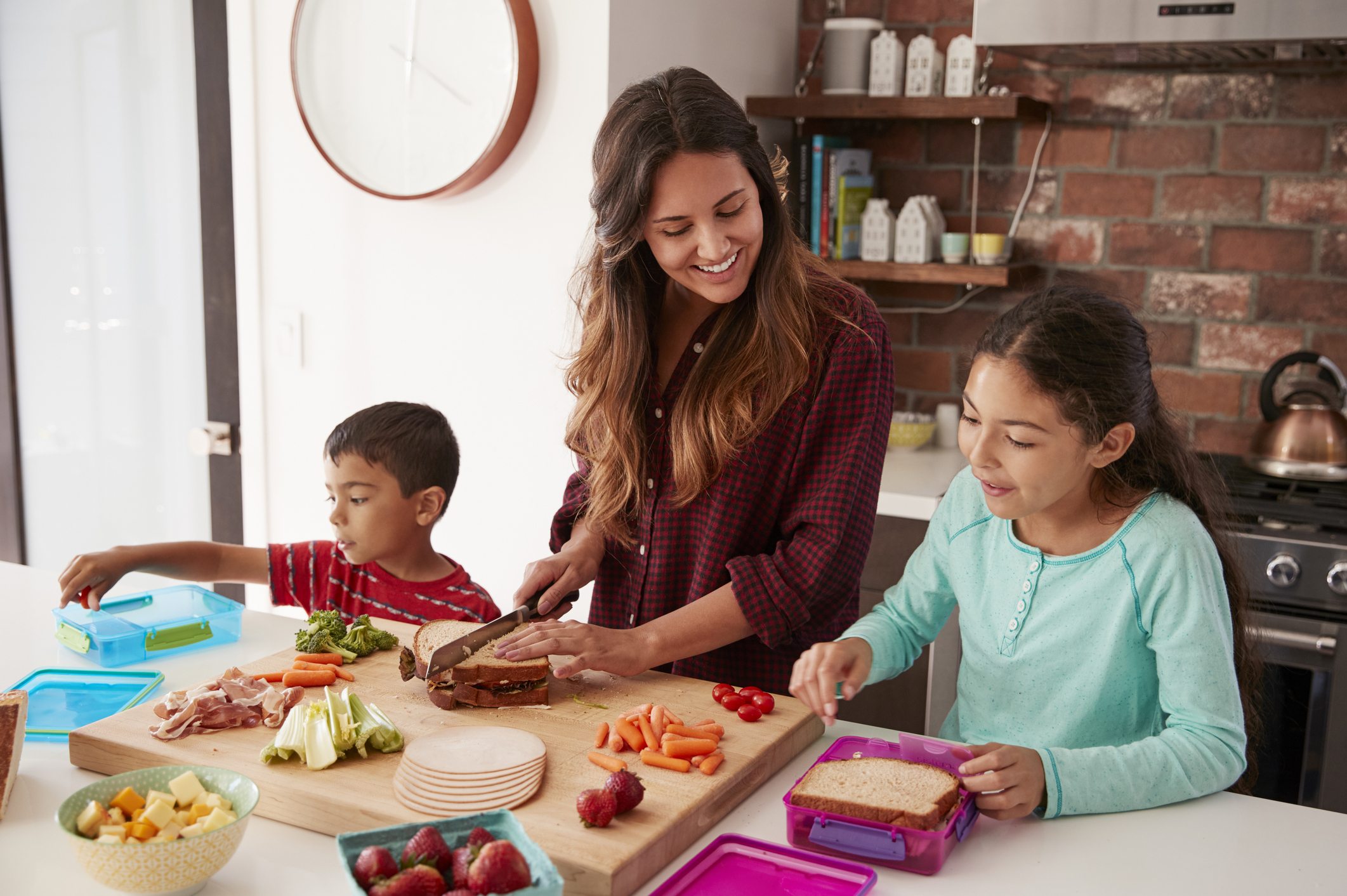 Mom with two school-aged kids in kitchen food prepping