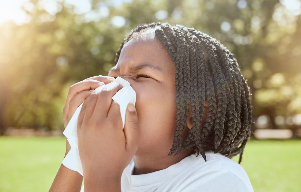 Child blowing nose outside, summer safety tips for those nose