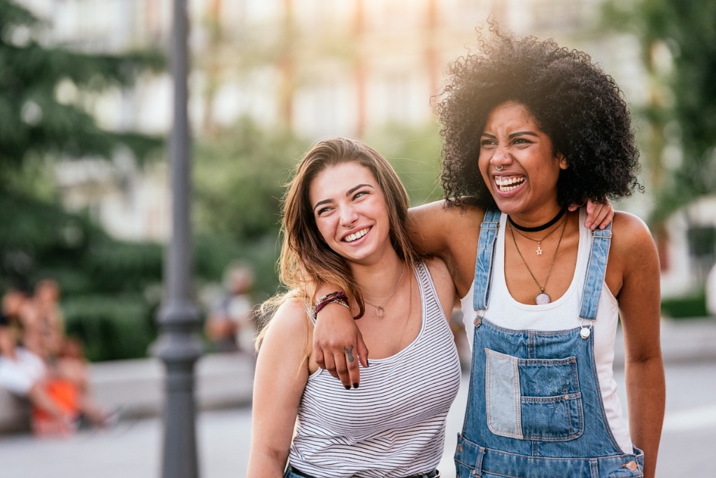 Teenage females smiling, in street. Motivate your teen this summer.