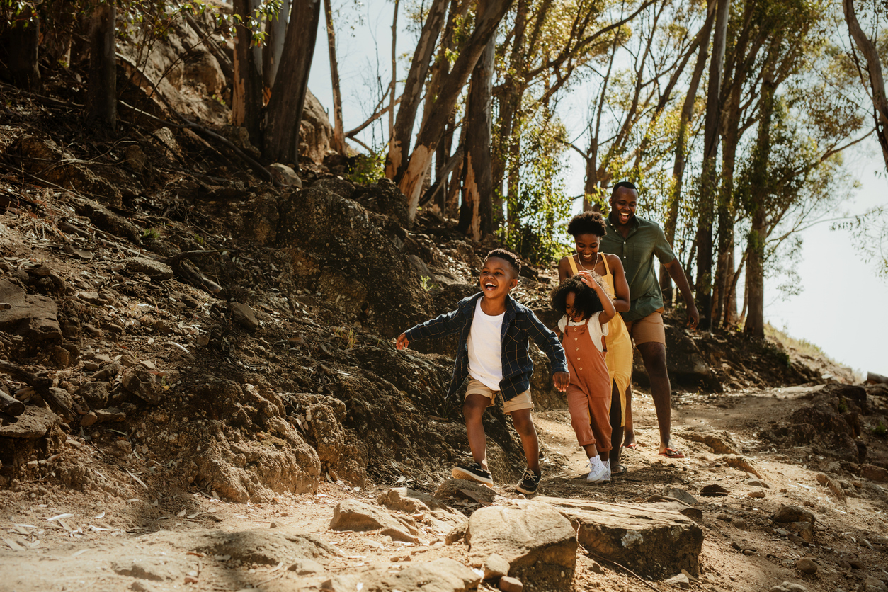 Family of 4 hiking in woods, having fitness challenge