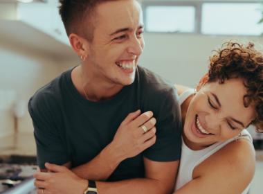 Young couple laughing and hugging in kitchen