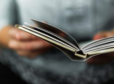 hands holding small book