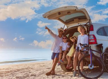 Family outside camper in summer, on beach