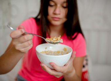 Teenage girl eating cereal