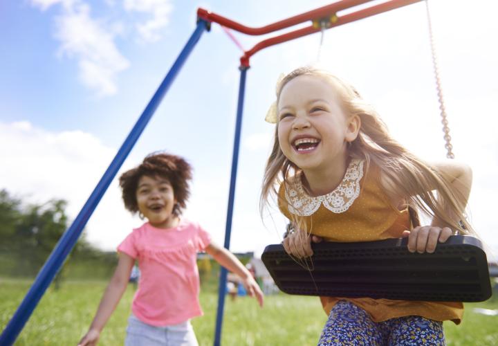 Two young girls playing joyfully on playground