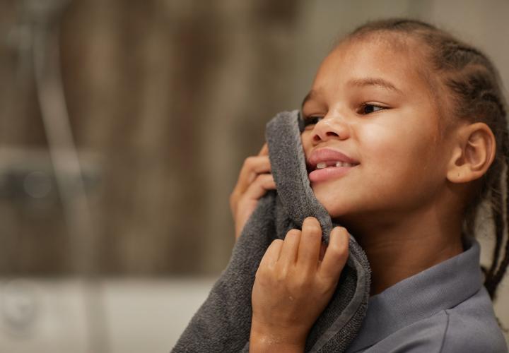Girl cleaning ear safely with cloth