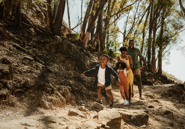 Family of 4 hiking in woods, having fitness challenge