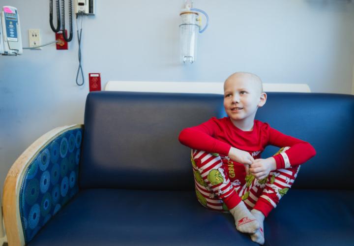 Child in hospital room, wearing holiday pajamas