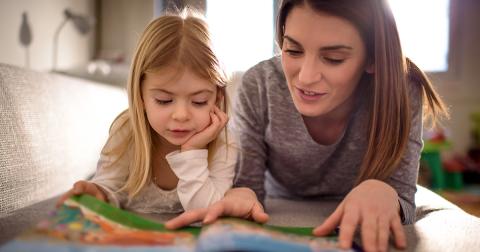 A mother and daughter look at a book together