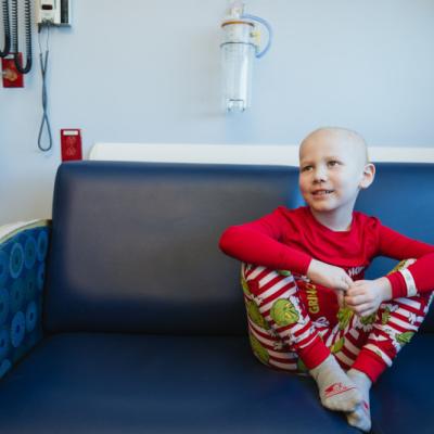 Child in hospital room, wearing holiday pajamas